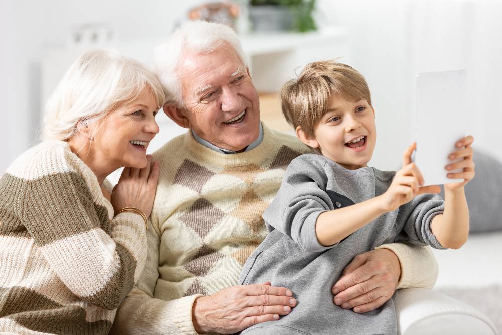 grands-parents avec leur petit fils faisant une visio grâce au rachat de crédits