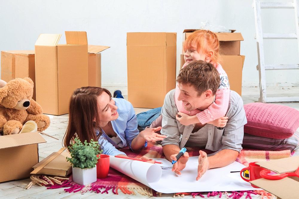 Famille, père, mère, fille, souriante qui prépare son déménagement.