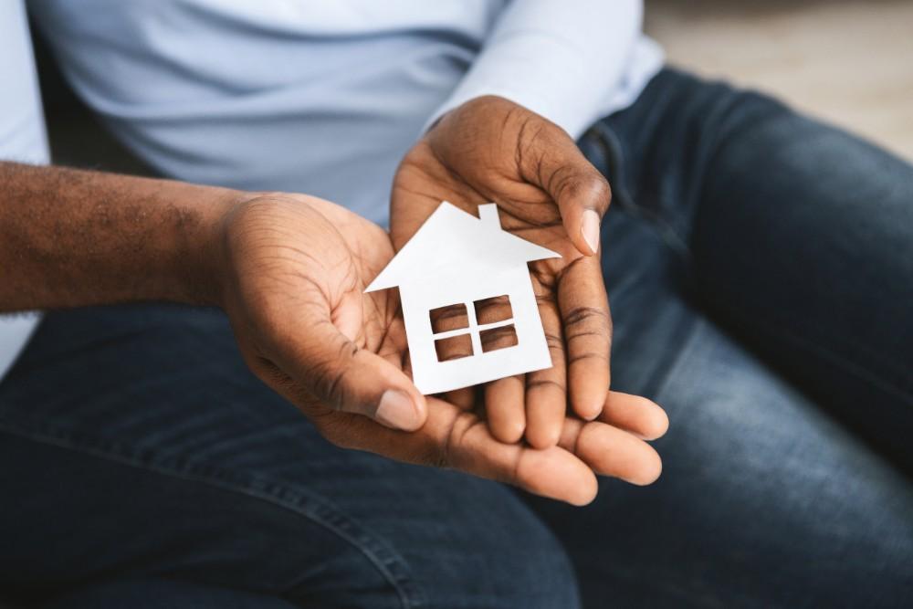 Petite maison en bois dans les mains d'un homme